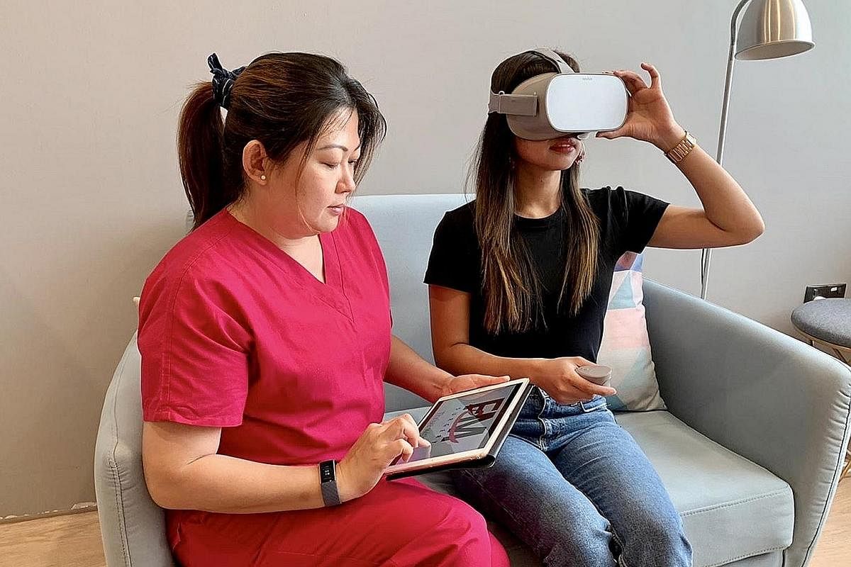 Nurse Chong Pei San with a patient who is watching a virtual-reality video on breast wide excision and sentinel lymph node biopsy through a headset.