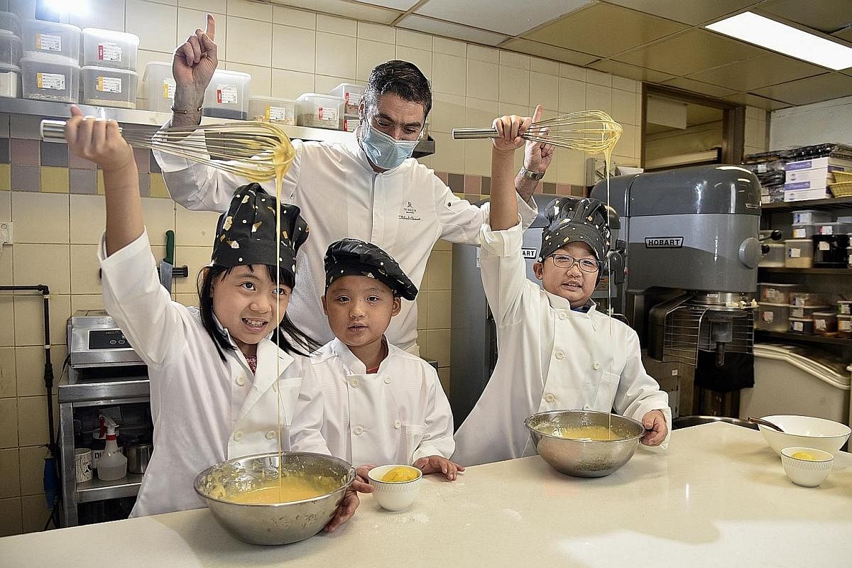 St Regis Singapore's executive chef Thibault Chiumenti guiding a Madeleine-making session and teaching kids to whisk and fold the batter. The St Regis Singapore lobby (above). The interiors of the hotel display old-world palatial charms. A teepee pad