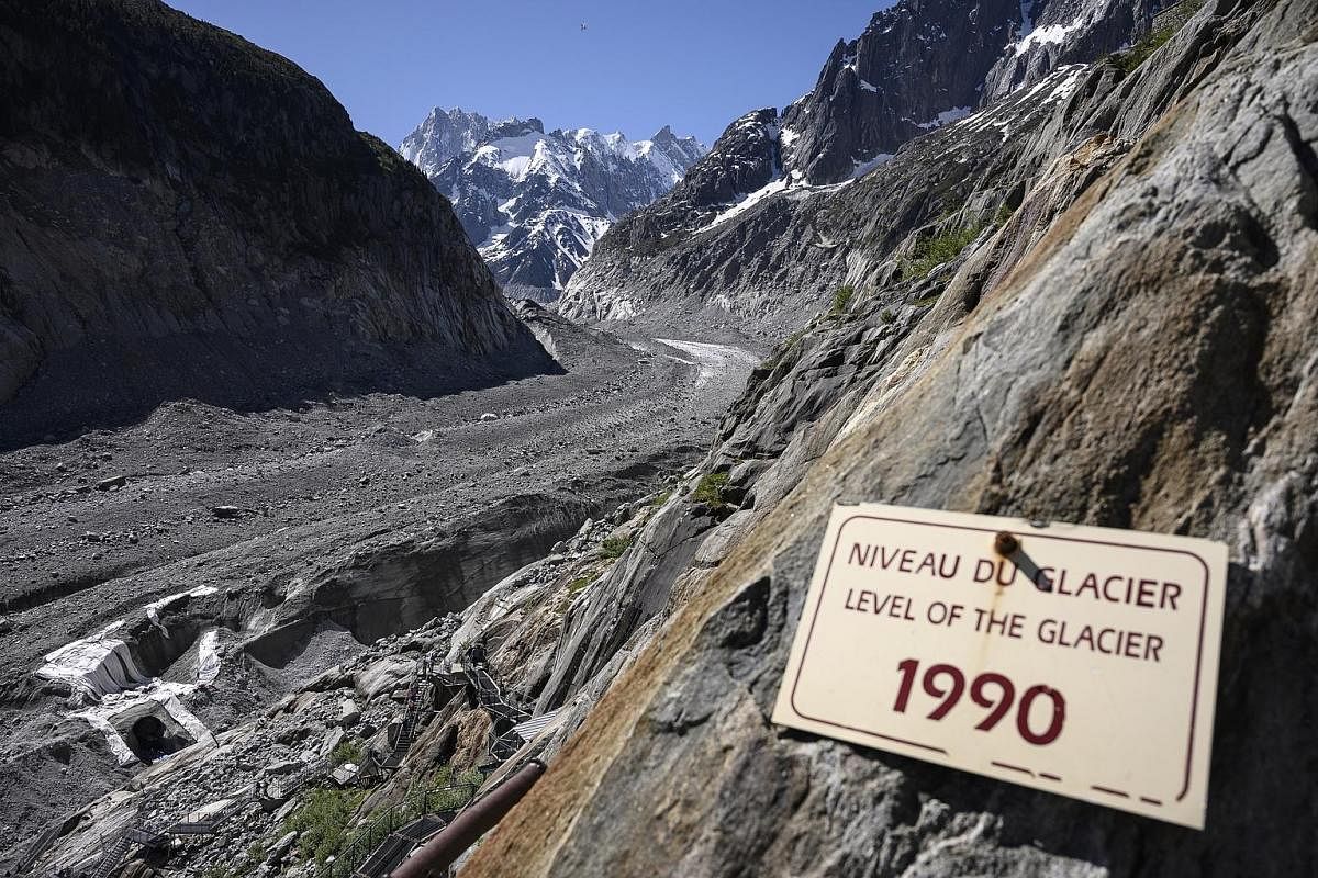 A 2019 photo of a board indicating the level of the Mer de Glace glacier in France in 1990. The glacier has shrunk drastically over the past three decades. According to a New Scientist report in 2019, visitors exiting a nearby train station could des