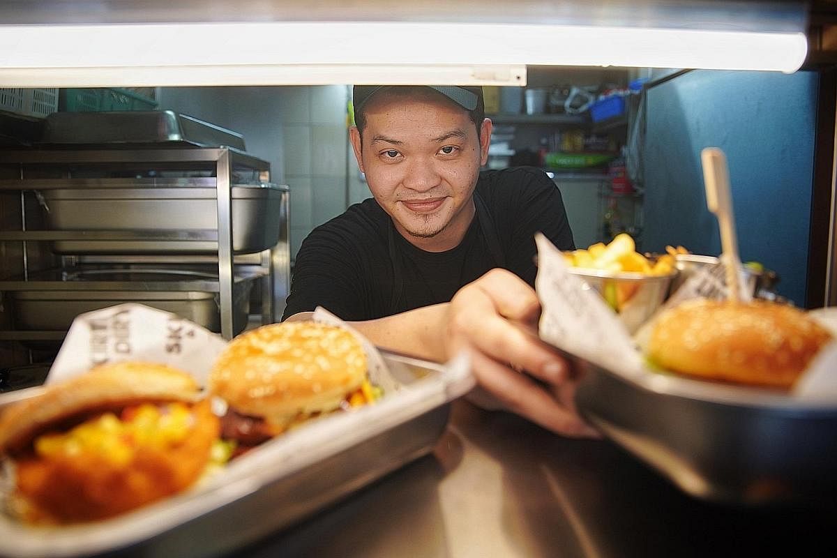 Responding to customers' feedback, Mr Fabian Tan changed his menu four times during the first four months of operations at his burger stall Mr Sheik Mohammad with a plate of his bestseller, the combo platter dulang ($30) that has a bit of everything 