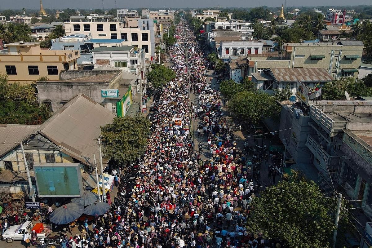 Above: Protesters marching in Myanmar's Sagaing region yesterday during a demonstration against the military coup in the country. Top left: Young Myanmar women wearing wedding gowns joining a protest last Wednesday. They held up signs that said: "Get