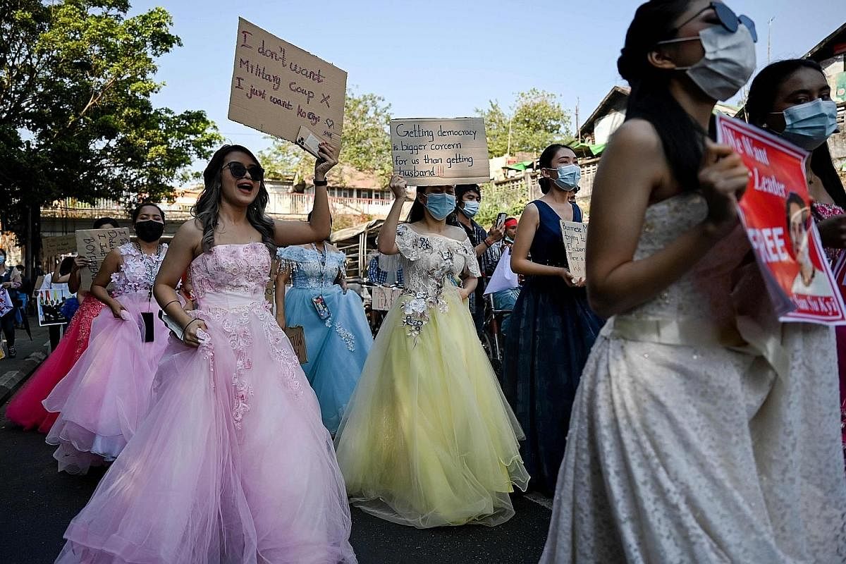 Above: Protesters marching in Myanmar's Sagaing region yesterday during a demonstration against the military coup in the country. Top left: Young Myanmar women wearing wedding gowns joining a protest last Wednesday. They held up signs that said: "Get