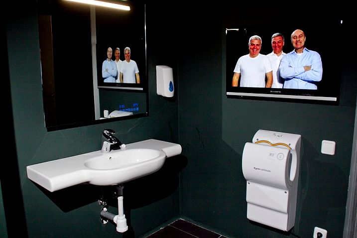 When you sit on the toilet at Miba, a video comes on: Three men walk on and off screen, looking and gesturing at you.